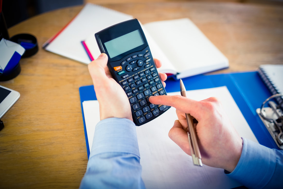 man holding a calculator and pen